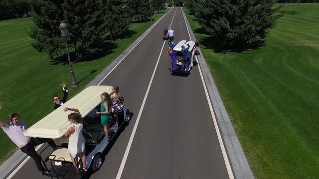Guys have fun on golf cars.