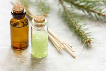 Bottles of essential oil and fir branches for aromatherapy and spa on white table background