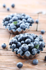 Ripe and tasty blueberries on brown wooden table