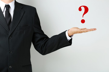 Businessman gesturing with his hand on grey background