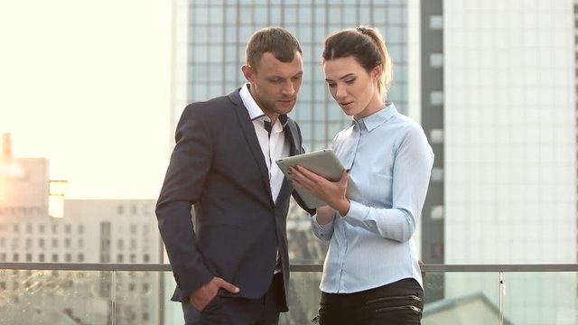 Man and businesswoman holding tablet. People on city background. Importance of common goals.