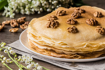 Delicious pancakes on wooden table with walnuts.