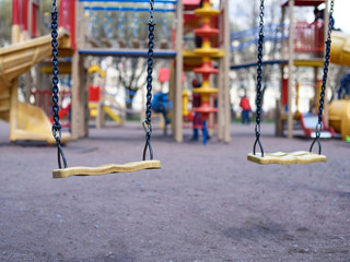 Two empty swings on children's playground.