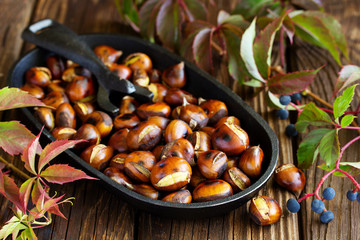 Roasted chestnuts on an old board. Selective focus.