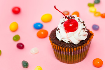 cupcake with sweets on pink background