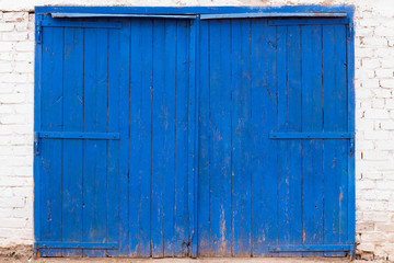 blue wooden door, the edges of the wall with white bricks