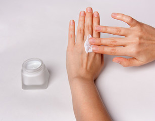 Female hand with cosmetic cream isolated on white background.