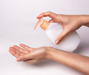 Female hands using wash hand sanitizer gel pump dispenser.