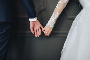 Newlyweds hold hands.