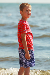 Fototapeta na wymiar Boy walking on beach.