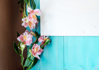 Spring background layout on a blue wooden background with flowers blackboard 