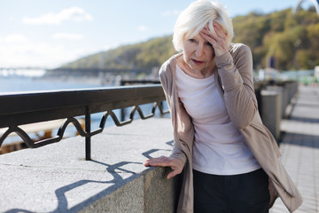 Fototapeta premium Distressing pensioner having headache in the street