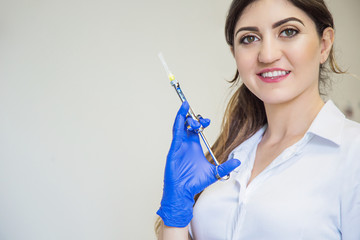 Beautiful doctor in blue gloves with anesthetic aspirating syringe. Dentist nurse. Cosmetology. Dentist prick. Dental tools