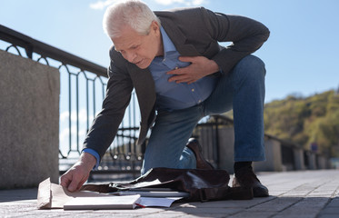 Old man finding unexpected envelope in his bad in the street