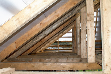 Fototapeta na wymiar Building Attic Interior. Wooden Roof Frame House Construction. Roofing Construction Indoor.