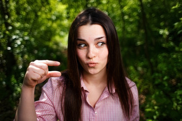 Portrait of mocking or extremely surprised  of something small woman, showing small thing in a...