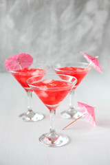 Raspberry cocktail with ice and paper umbrellas