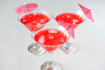 Raspberry cocktail with ice and paper umbrellas