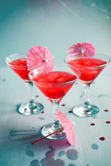 Raspberry cocktail with ice and paper umbrellas