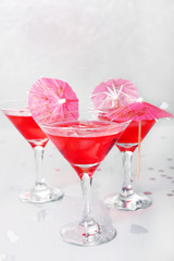 Raspberry cocktail with ice and paper umbrellas