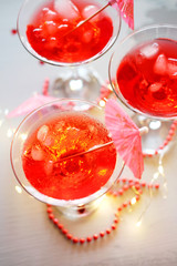 Raspberry cocktail with ice and paper umbrellas