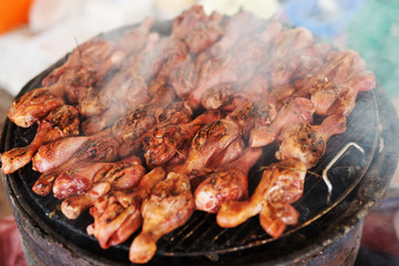 Chicken legs on a grill. Summer barbeque in nature.
