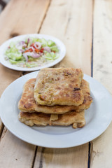 Roti Parata or Roti canai with curry sauce on wooden background.