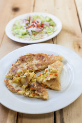 Roti Parata or Roti canai with curry sauce on wooden background.
