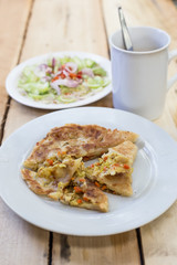 Roti Parata or Roti canai with curry sauce on wooden background.