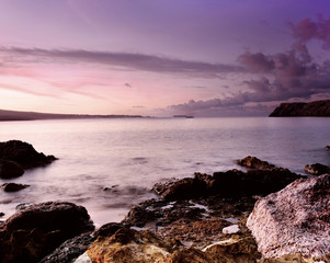 Beautiful colorful sunrise at the sea with dramatic clouds and boulders. Beauty world natural outdoors travel background