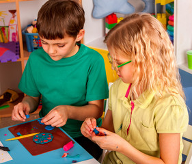 Plasticine modeling clay in children class. kids together play dough and mold from plasticine in kindergarten or preschool. Group of four people. Teaching modeling.