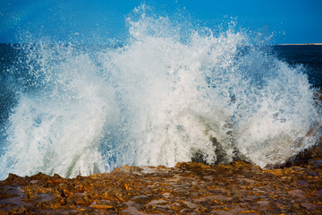 Obraz premium Sea wave splashing on rocks, natural holiday vintage hipster seasonal background