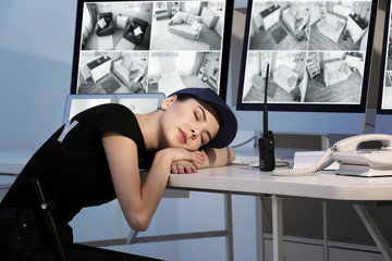 Beautiful security guard sleeping in surveillance room