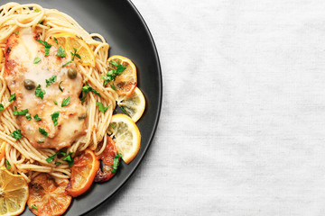 Plate with delicious Italian chicken piccata on table