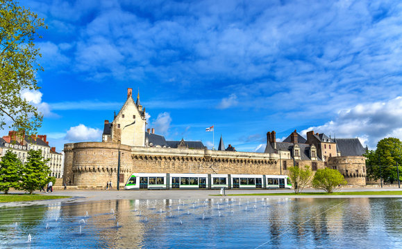 Castle of the Dukes of Brittany, a City tram and the Water Mirror fountain in Nantes, France