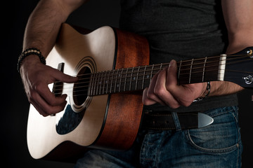 Fototapeta premium Playing guitar. Acoustic guitar in the hands of the guitarist. Horizontal frame