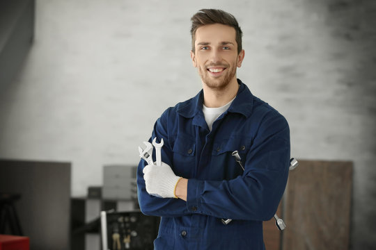 Auto mechanic with tools in car repair shop
