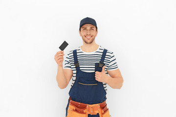 Handsome worker with business card on white background