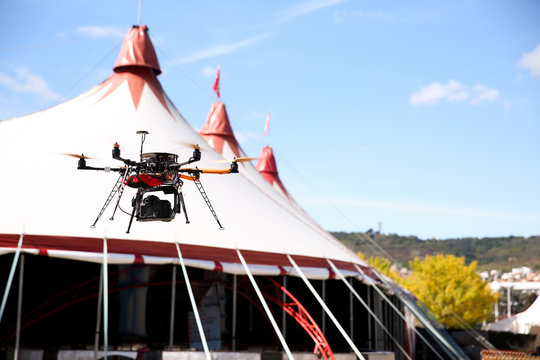 Drone avec appareil photo durant événement festival et cirques. Ciel bleu nuages montagnes paysages.