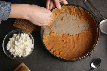 Hands of woman preparing cheesecake in kitchen