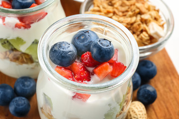 Glass jar with tasty yogurt and berries, closeup