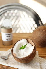 Coconut cream in nut on wooden table