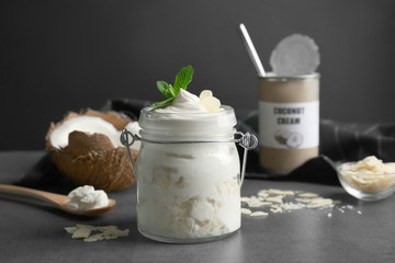 Delicious coconut cream in jar on dark background