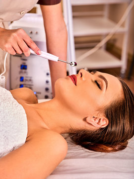 Facial massage at beauty salon. Electric stimulation skin care of woman. Equipment for microcurrent lift face. Anti aging neck non surgical treatment. Modern technologies and methods of rejuvenation.