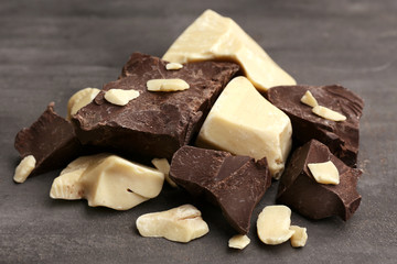 Chunks of dark and white chocolate on grey background