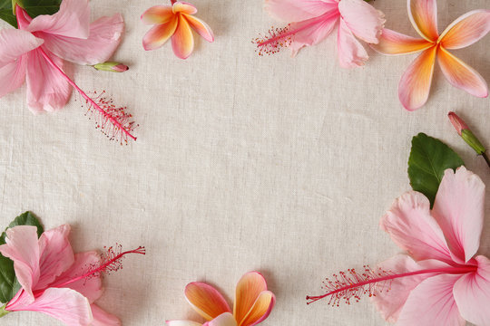 Pink and orange summer flowers on linen, copy space background