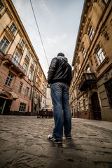 Obraz na płótnie Canvas man walking by old europian city