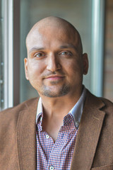 Closeup headshot portrait, happy handsome indian business man, smiling, confident and friendly indoors.