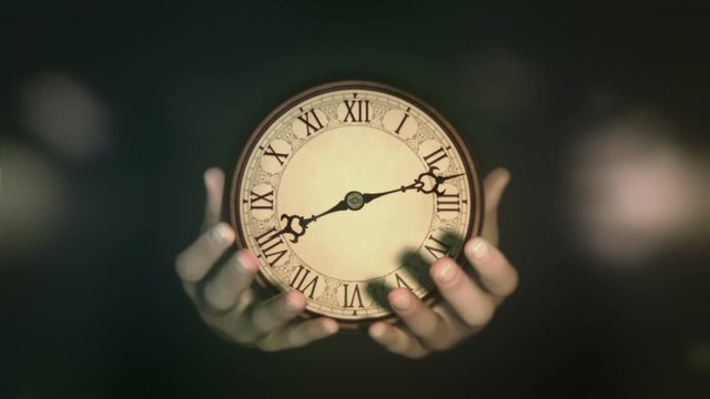 Passing of time. Hands holding fast turning clock. Natural grading version.