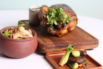 Grilled whole chicken with mushroom rice and cabbage on wooden board